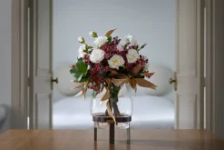 Artificial fall bouquet in a standing glass vase