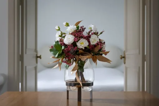 Artificial fall bouquet in a standing glass vase