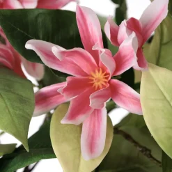 Artificial pink magnolia flower bouquet in a vase