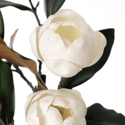 Artificial white magnolia flowers in a green vase