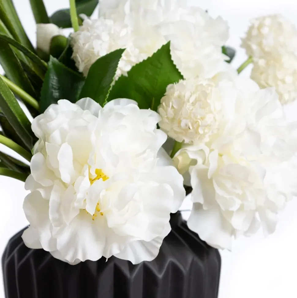 Small white flower bouquet in a black vase